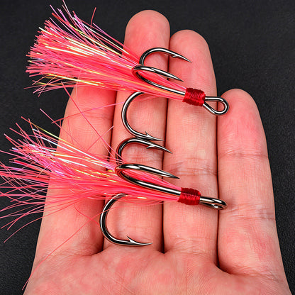 Handhold close-up of Proberos SZ140 black treble hook with red flash feather
